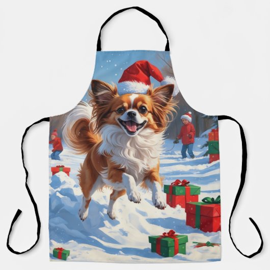 クリスマスの帽子をかぶったパピヨンの犬が雪の中を走る エプロン (正面)