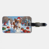 クリスマスの帽子をかぶったパピヨンの犬が雪の中を走る ラゲッジタグ (裏面横)