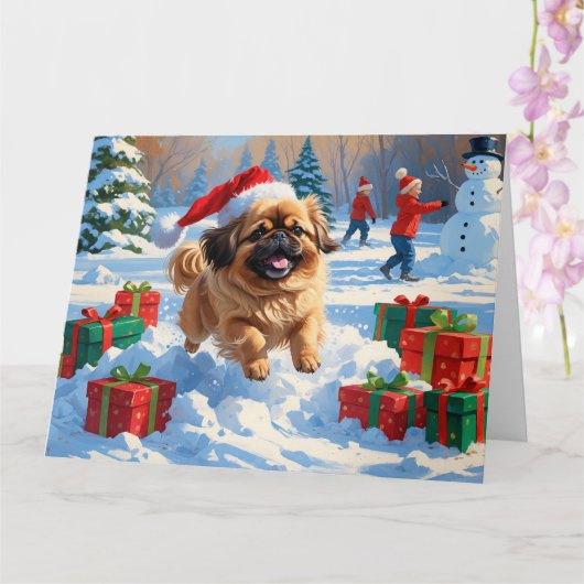 クリスマスの帽子をかぶった北京原産犬の雪の中のランニング カード (蘭)