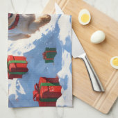 クリスマスの帽子をかぶって雪の中を走るケアン・テリア キッチンタオル (四つ折り)