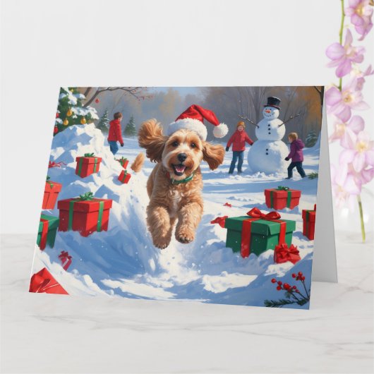クリスマスの帽子をかぶって雪の中を走るコッカプー カード (蘭)