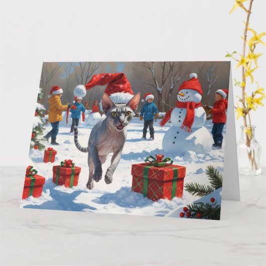 クリスマスの帽子をかぶって雪の中を走るスフィンクス猫 カード (黄色い花)