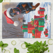 クリスマスの帽子をかぶって雪の中を走るドーベルマン キッチンタオル (折り畳み)