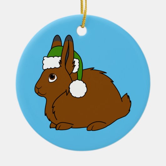 クリスマスの緑のサンタの帽子が付いているブラウンの北極ノウサギ セラミックオーナメント (正面)