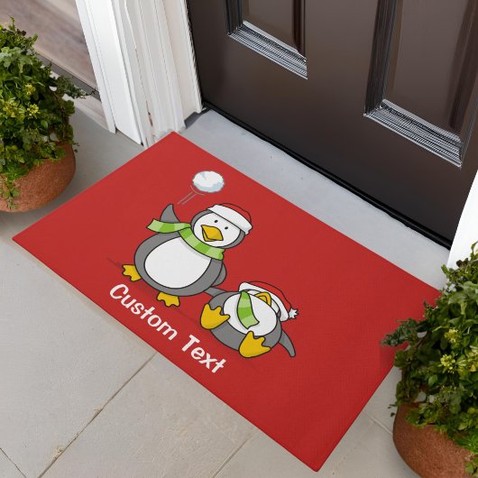 クリスマスの雪玉遊びをするペンギン ドアマット