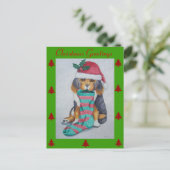 クリスマスを伴うかわいい黒と茶色の子犬ストッキング シーズンポストカード (スタンド正面)