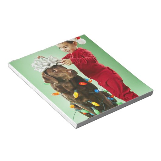 クリスマスを飾る若い男のまわりにの子が犬を照らす ノートパッド (アングル)