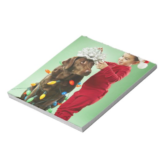 クリスマスを飾る若い男のまわりにの子が犬を照らす ノートパッド (回転)