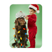 クリスマスを飾る若い男のまわりにの子が犬を照らす マグネット (縦)