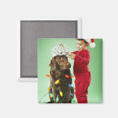 クリスマスを飾る若い男のまわりにの子が犬を照らす マグネット (正面/裏面)