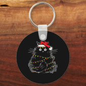 クリスマスツリーの光に照らされたサンタ黒猫 キーホルダー (正面)