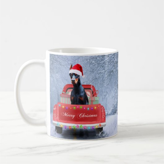 クリスマストラックに座って雪の中のドバーマンドッグ コーヒーマグカップ (左)
