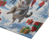 クリスマスハットをかぶったシベリアンキャットが雪の中で走る カッティングボード (角)