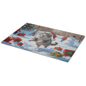 クリスマスハットをかぶったシベリアンキャットが雪の中で走る カッティングボード (角)