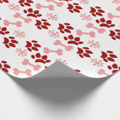 クリスマスピンクの赤い犬の猫が骨の雪のかけらを歩く ラッピングペーパー (角)