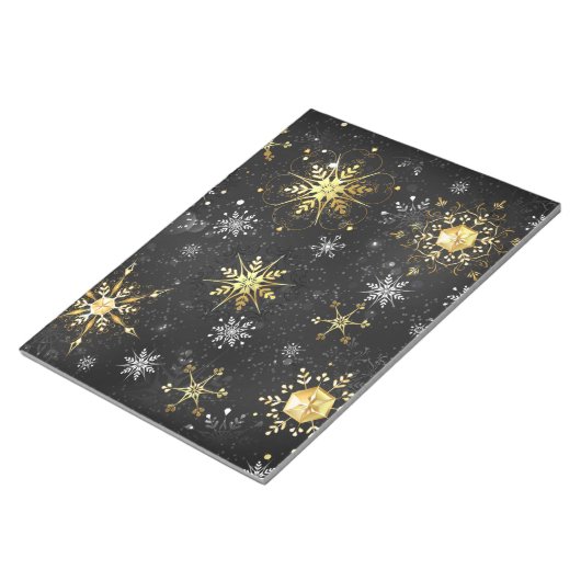クリスマスブラックバックグラウンド上のゴールデンスノーフレーク ノートパッド (アングル)