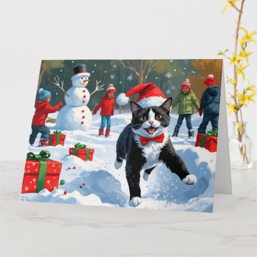 クリスマス帽子をかぶったタキシード猫の雪の中の奔走 カード (黄色い花)