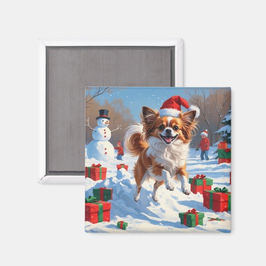 クリスマス帽子をかぶったパピヨンの犬が雪の中を走る マグネット (正面/裏面)
