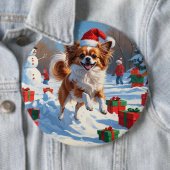 クリスマス帽子をかぶったパピヨンの雪中奔走 缶バッジ (インサイチュ)