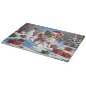 クリスマス走ハットで雪の中のパピロン犬 カッティングボード (角)