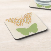 クリームの背景に飾り蝶のパターン コースター (左側)