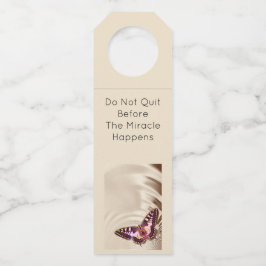 クリームサテンの背景のピンクの蝶 ボトルネックタグ