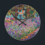 クロード・モネ- Monetの庭のファインアートのアイリス ラウンド壁時計<br><div class="desc">1900のショーからのキャンバスのこの油Monetの庭の花そしてヤナギの木の美しい表示。</div>