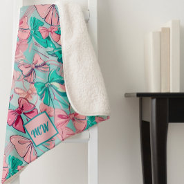 コケットピンク、ティール（緑がかった色）、マゼンタボウをテーマにしたモノグラム シェルパブランケット