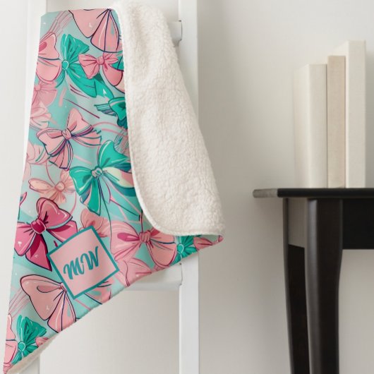コケットピンク、ティール（緑がかった色）、マゼンタボウをテーマにしたモノグラム シェルパブランケット
