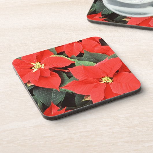 コルクのコースターの置かれる赤いポインセチア コースター (左側)