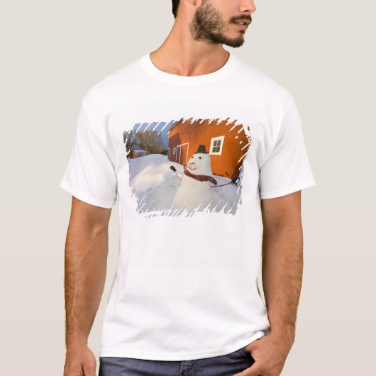 コロンビアフォールズの赤い納屋の前の雪だるま Tシャツ (正面)