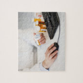 コンピューターにピルボトルを持つ薬剤師 ジグソーパズル (縦)