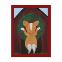 コーギーが犬小屋にクリスマスリースを飾っている