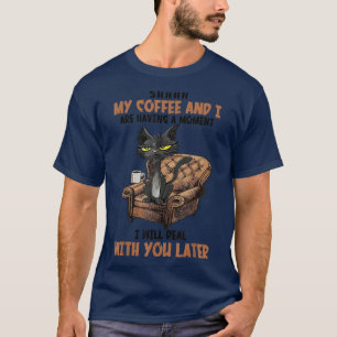コーヒーを飲みながら猫を飼っていおもしろいる Tシャツ