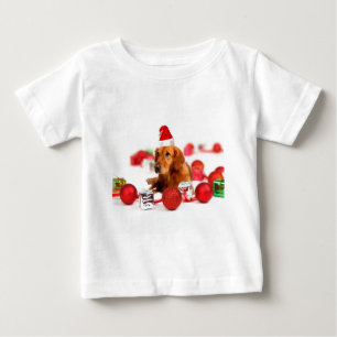 ゴールデンレトリバーの犬のクリスマス 赤いサンタ帽子 ベビーTシャツ