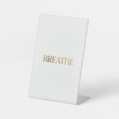 ゴールドの文字で"breathe"と書かれたミニマリストのタイポグラフィ 台座サイン (正面)