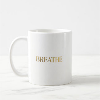 ゴールドの文字で"breathe"と綴られたミニマリストのタイポグラフィ コーヒーマグカップ