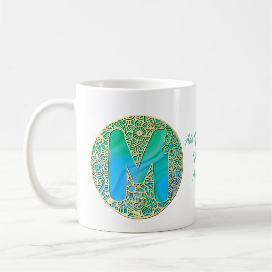 ゴールド、ターコイズの文字Mとカラフルな花 コーヒーマグカップ (左)