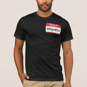 サスカッチの名前入りの記章のTシャツの大きい足のからかい Tシャツ