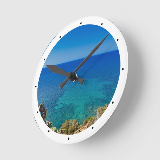 サルデーニャの青い海と空に地中海の低木が生い茂る ラウンド壁時計 (傾斜)