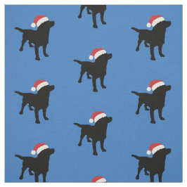 サンタのクリスマスの帽子を身に着けている黒い実験室犬 ファブリック