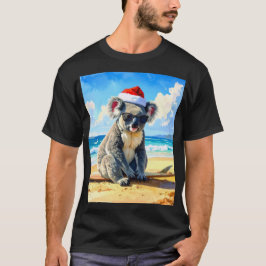 サンタの帽子をかぶったクリスマスコアラが日差しあふれる砂浜のビーチでくつろぐ Tシャツ