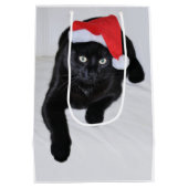 サンタの赤い帽子を持つ黒猫 ミディアムペーパーバッグ (裏面)