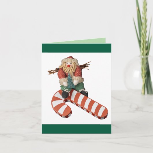 サンタクロースが赤いしま模様のキャンディークレーンを滑り降りるクリスマス シーズンカード (正面)