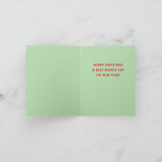 サンタクロースが赤いしま模様のキャンディークレーンを滑り降りるクリスマス シーズンカード (内部)