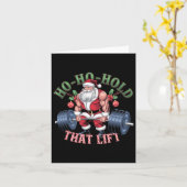 サンタクロースのクリスマスジムを持ち上げるホホホホホールド カード (黄色い花)