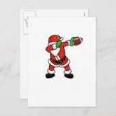 サンタクロースの軽く押えるクリスマスのフットボールの接地 シーズンポストカード (正面/裏面)