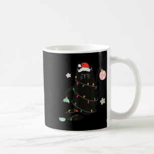 サンタクロースの黒猫がクリスマスツリーのイルミネーションに絡まってる コーヒーマグカップ