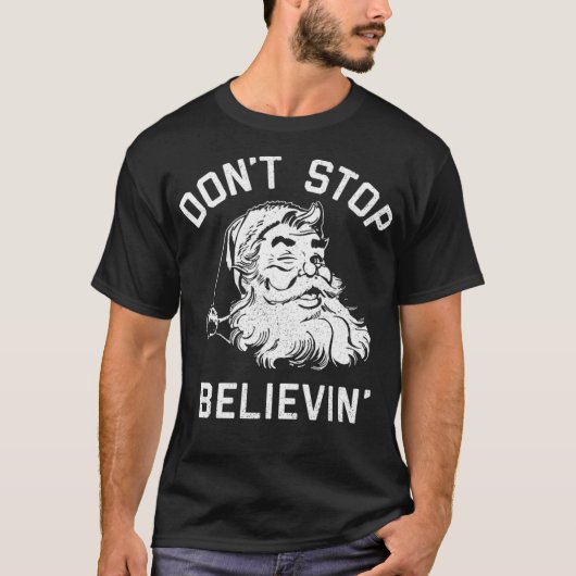 サンタクロースは信じることをやめない 面白いクリスマスパンツ Tシャツ (正面)
