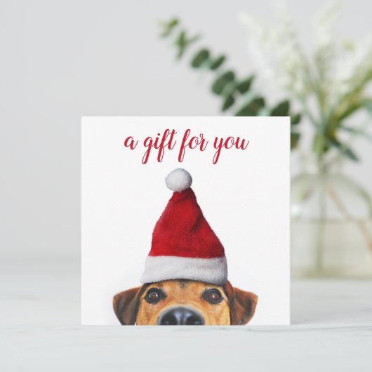 サンタハットギフトカードを持つ好奇心に満ちた可愛いおもしろい犬 (スタンド正面)